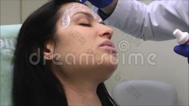 <strong>抗衰</strong>老程序：皮肤科医生把乳膏涂在一个深色皮肤的脸上